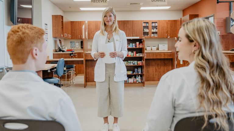 Photo du laboratoire de pharmacie avec étudiante, étudiant et enseignante